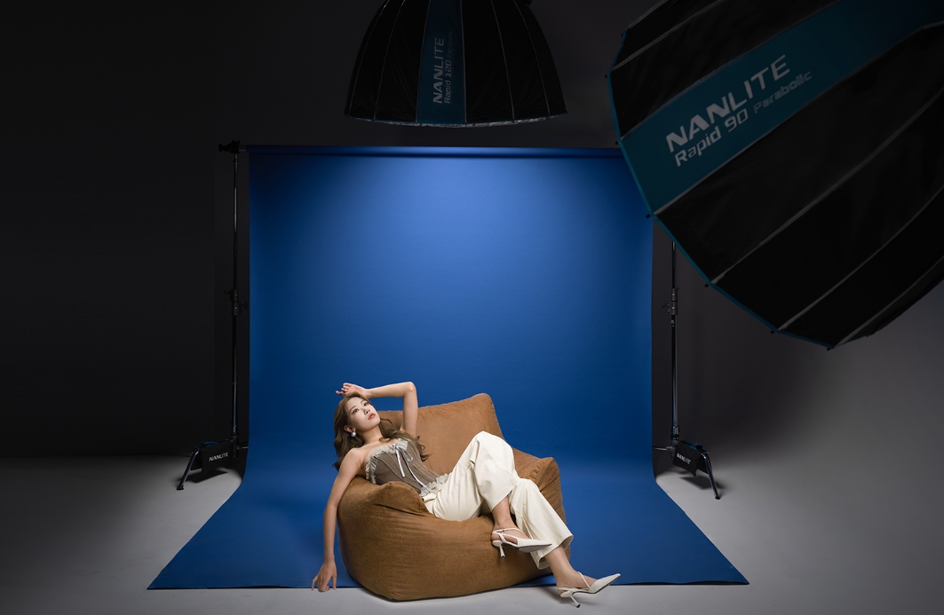 Softbox สำหรับถ่ายภาพบุคคล การจัด Softbox ขนาดใหญ่ถ่ายภาพบุคคลบนเก้าอี้หน้าฉากสีน้ำเงิน